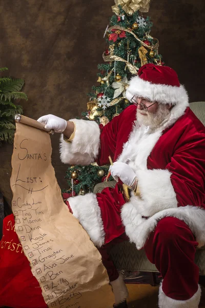 Santa claus zijn lijst controleren — Stockfoto