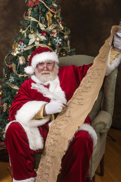 Kerstman zijn lijst controleren — Stockfoto