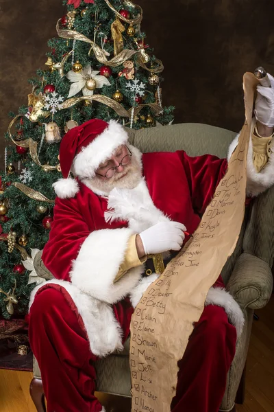 Santa claus zijn lijst controleren — Stockfoto