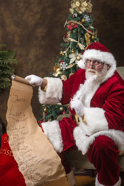 Santa claus zijn lijst controleren — Stockfoto