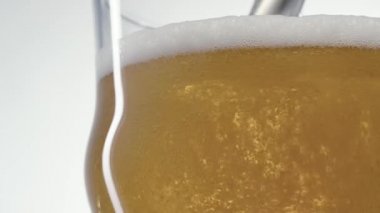 Köpüklü bira bardağa ağır çekimde dökülür.