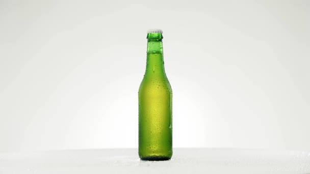 방울을 넣은 차가운 맥주 병은 360 도 회전한다 — 비디오