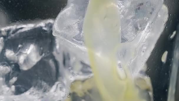 Glace dans un verre de jus. Macro — Video