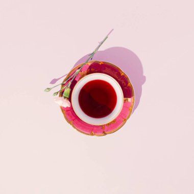 Pastel pembe arka planda beyaz çiçekli kadim çay fincanı. Minimum düzlük.