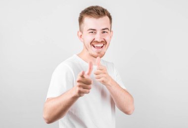 İzole edilmiş arka planda genç yakışıklı bir adam kamerayı işaret ediyor ve sen, el işareti, ön taraftan pozitif ve kendinden emin bir hareket..