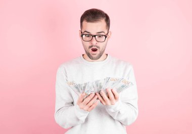 Genç, güzel, beyaz bir adam piyangoyu kazanınca şok oldu. Adam kadının kazandığı para tomarına bakıyor.