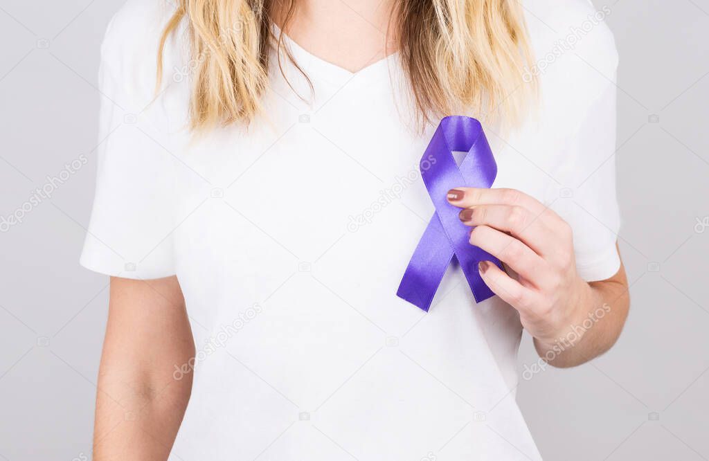 Woman holding purple ribbon on white background. Alzheimer's disease, Pancreatic cancer, Epilepsy awareness, world cancer day, Domestic violence awareness concept.