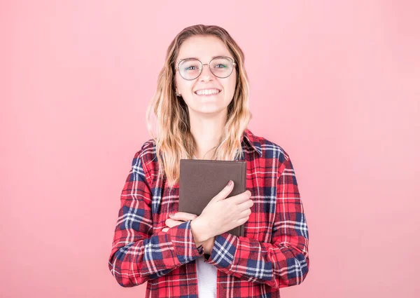 Elinde günlükle neşeli genç kıvırcık kız neşeli ve büyüleyici bir gülümsemeyle kameraya bakıyor..