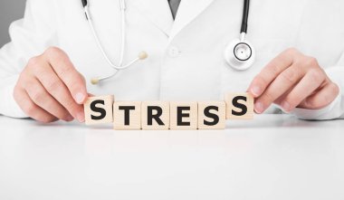 Doktor elindeki tahta küpleri STRESS yazısıyla tutuyor.