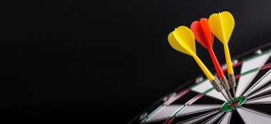 Dart tahtasının ortasına kırmızı ve sarı oklar. Başarı, hedefler ve hedefler kavramı..