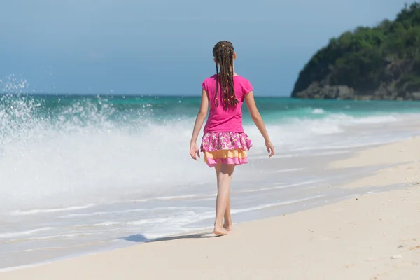 a little girl walking away on beach
