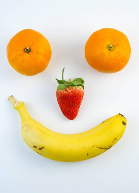 Muz, çilek ve portakaldan yapılmış mutlu ve üzgün yüzler.