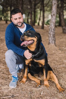 Adam sevgiyle köpeğiyle oynuyor.