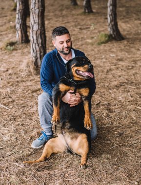 Adam sevgiyle köpeğiyle oynuyor.