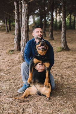 Adam sevgiyle köpeğiyle oynuyor.