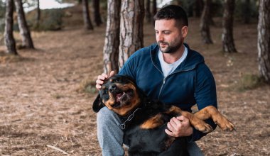 Adam sevgiyle köpeğiyle oynuyor.