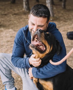 Adam sevgiyle köpeğiyle oynuyor.