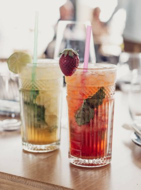 İki mojito kokteyli, yıllanmış rom, nane ve farklı meyvelerden yapılır. Biri çilek, diğeri tutku meyvesi.