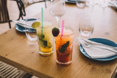 İki mojito kokteyli, yıllanmış rom, nane ve farklı meyvelerden yapılır. Biri çilek, diğeri tutku meyvesi.