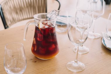 Kırmızı şarap ve meyve suyuyla yapılmış limon sürahisi. Restoranda iki bardak.