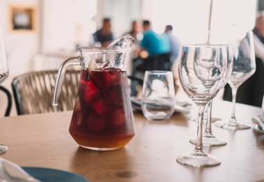 Kırmızı şarap ve meyve suyuyla yapılmış limon sürahisi. Restoranda iki bardak.