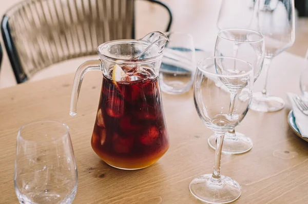 Kırmızı şarap ve meyve suyuyla yapılmış limon sürahisi. Restoranda iki bardak.