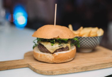 Gurme çizburger, ev yapımı ekmek ve yanında patates kızartması ile servis edilir.