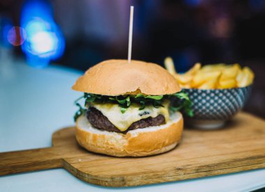 Gurme çizburger, ev yapımı ekmek ve yanında patates kızartması ile servis edilir.