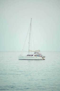 Sakin bir denizde küçük bir yelkenli