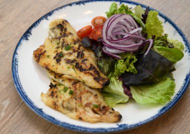 Taze bahçe salatası ve kiraz domatesli ızgara balık filetosu.