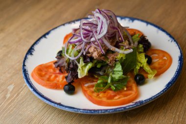 Ton balıklı salata, marul, kırmızı soğan, siyah zeytin ve domates.