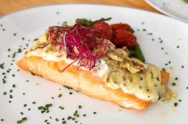 Beyaz tabakta mantar soslu somon bifteği. 