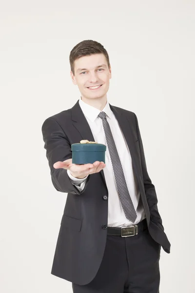 Handsome young man with gift box — Stock Photo, Image