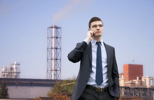 Bello giovane uomo d'affari sullo sfondo edificio industriale — Foto Stock