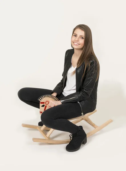 Teenage girl riding a rocking horse — Stock Photo, Image