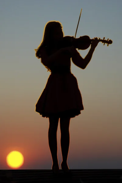 Jeune fille avec violon sur fond de coucher de soleil — Photo