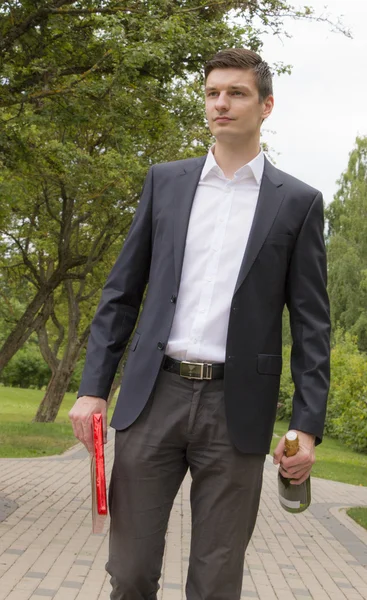Young man with champagne and chocolates — Stock Photo, Image