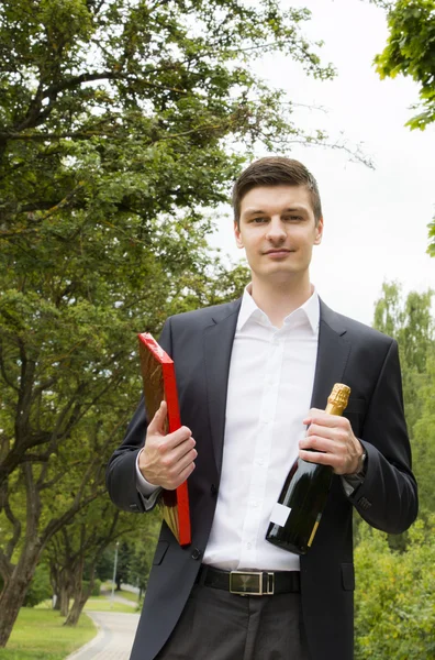 Young man with champagne and chocolates — Stock Photo, Image