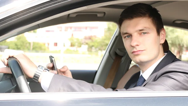 Bello giovane uomo d'affari seduto in macchina — Foto Stock
