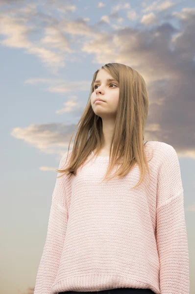 Adolescente chica en el cielo nublado fondo Imágenes de stock libres de derechos