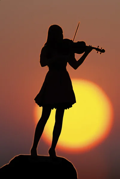 Jeune fille avec violon sur fond de coucher de soleil — Photo