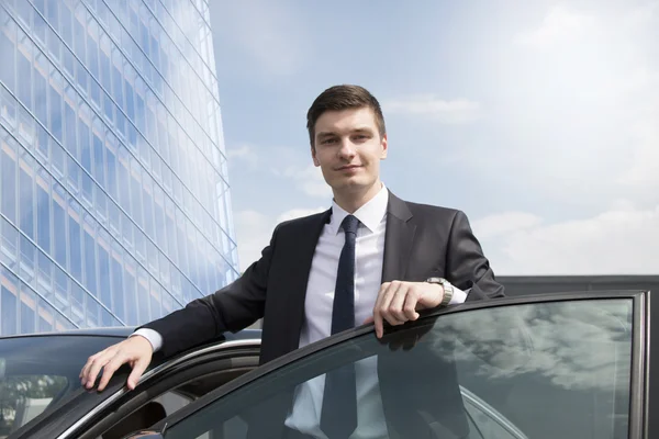 Giovane uomo d'affari in piedi vicino alla sua auto — Foto Stock