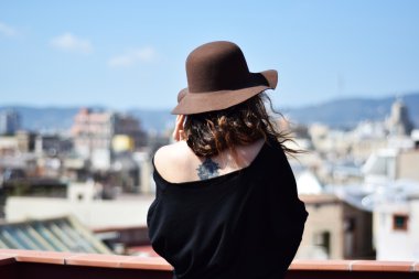 Yalnız genç kadın kahverengi şapkalı düşünme geri Teras, Barcelona, Gotik Semti üzerinden