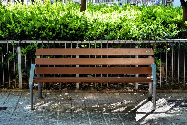 Деревянная скамейка, зеленые растения на заднем плане — стоковое фото