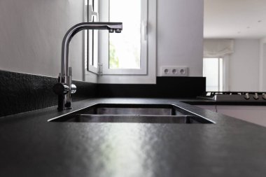 A double bowl stainless steel kitchen sink in a modern style, steel chrome water tap in the kitchen