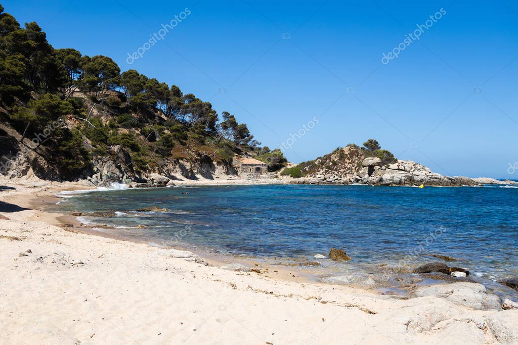 Cala estreta in Palamos, Costa Brava, Spain, sandy beach with sea and rocky mountain