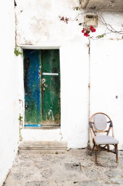 Eski Beyaz Saray 'da sandalyesi olan eski yeşil kapı, İbiza eski kasabası.