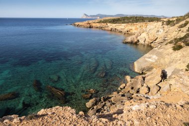Ibiza 'da Cala roja, kristal mavi suyu olan kayalık deniz kıyısı, İspanya
