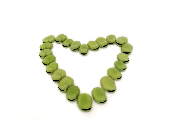 Сердце из зеленых бобов, изолированных на белом фоне
