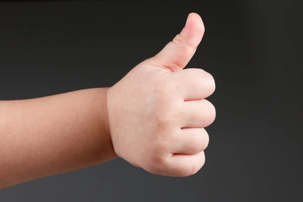 Approval thumbs up like sign, child hand gesture  over dark background — Stock Photo, Image
